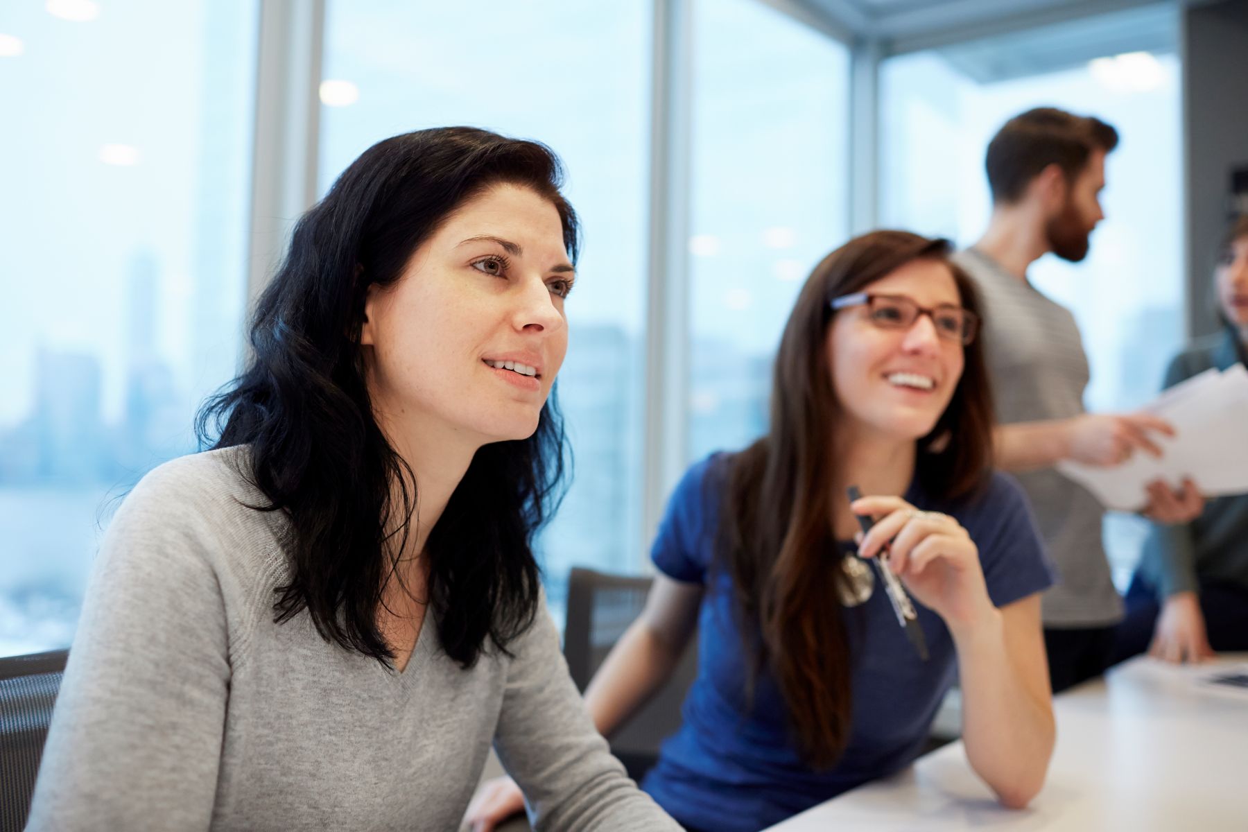 female office workers sat at table talking